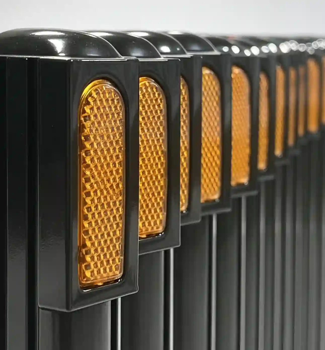 retractable road barrier, close-up of honeycomb amber reflective warning reflector for telescopic traffic safety barrier