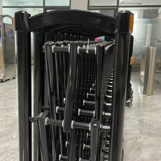 Black manual stainless steel retractable accordion road barrier in a showroom
