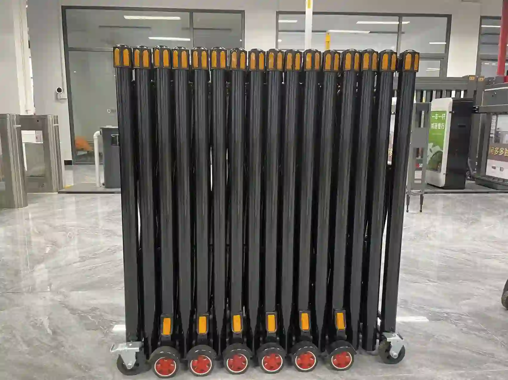 Folded manual accordion road barrier, retractable stainless steel security fence with reflective markers and casters, compact storage design